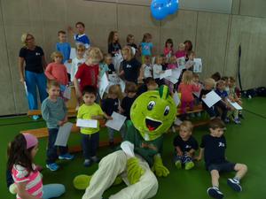 Bild vergr��ern: Der Drache �Jolinchen� �berraschte die j�ngsten Aktiven des TSV Burbach und �berreichte ihnen das Sportabzeichen. Unser Bild zeigt die muntere Kinderschar mit �Jolinchen� sowie den �bungsleiterinnen Andrea Bechtel (links) und Annette Bieler. Foto: TSV Burbach