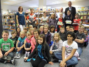 Bild vergr��ern: 27 Kinder aus den Grundschulen Burbach und Wahlbach waren beim diesj�hrigen Sommerferien-Lesespa� dabei, den Schule und Gemeindeb�cherei zum zweiten Mal veranstaltet haben. Die eifrigsten Leser, Cindy Kaufmann, Julia Henrici, Sebastian Diehl Kiara Rinck und Jana Marie Seibel (alle stehend im Hintergrund), erhielten Buchpreise von Thomas Vitt und B�rgermeister Christoph Ewers.