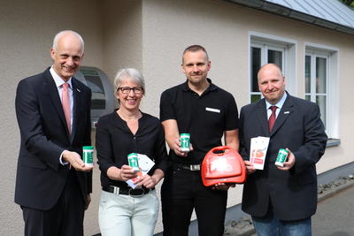 Bild vergr��ern: B�rgermeister Christoph Ewers, Seniorenbeauftragte Birgit Meier-Braun, Kai Langenbach, Sprecher Ersthelferkonzept Burbach und Fachbereichsleiter Jochen Becker (v. l.) pr�sentieren die Notfalldose, die jetzt auch in Burbach erh�ltlich ist.