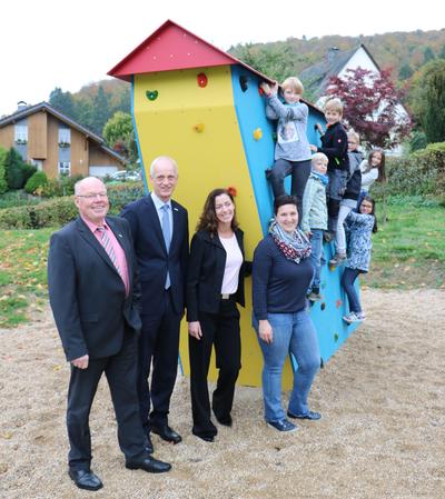 Bild vergr��ern: Thomas Leyener (l.) und Dr. Henrike Curdt (3.v.l.) vom Vorstand der Sparkassenstiftung, B�rgermeister Christoph Ewers und F�rdervereinsvorsitzende Eileen Schmidt mit Kindern der Grundschule bei der offiziellen �bergabe der Boulderwand