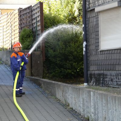 Bild vergr��ern: Zum Schutz des Nachbargeb�udes wurde von Mitgliedern der Jugendfeuerwehr eine Riegelstellung eingerichtet.