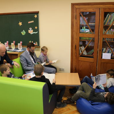 Bild vergr��ern: B�rgermeister Christoph Ewers und Daniel Ermert, Vorsitzender des F�rdervereins der Grundschule Burbach, schm�kern in B�chern gemeinsam mit den Sch�lerinnen und Sch�lern in der neu eingerichteten Leseecke