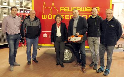 Bild vergr��ern: Renate St�ckermnann von der Sparkasse mit Vertretern der Feuerwehr bei der offiziellen �bergabe