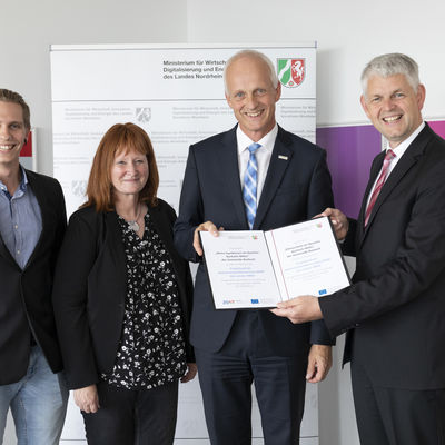 Bild vergr��ern: Wirtschaftsstaatssekret�r Christoph Dammermann �berreichte den F�rderbescheid an B�rgermeister Christoph Ewers, der Umweltbeauftragten Elisabeth Fley sowie dem Klimamanager Janis Dinter von der Gemeinde Burbach (v.r.n.l)