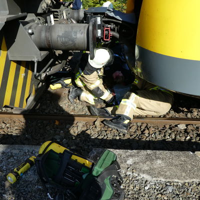Bild vergr��ern: Durch den Aufprall geriet eine Person unter den Zug. Dieser musste von den Feuerwehrleuten befreit werden.