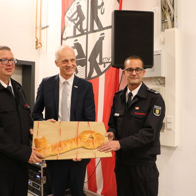 Bild vergr��ern: B�rgermeister Christoph Ewers (m.) und Leiter der Feuerwehr Markus Schwarze (r.) �bergaben symbolisch dem Einheitsf�hrer Tobias Schmidt (l.) einen gebackenen Schl�ssel zur Einweihung des Feuerwehrger�tehauses