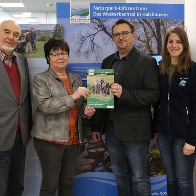 Bild vergr��ern: Vorstandsmitglied Friedrich Henstorf und Jutta Capito, Vorsitzende des
Naturparkausschusses, �berreichen im Burbacher Interimsstandort der Sparkasse Burbach-
Neunkirchen, Hauptstandort Burbach, eine druckfrische Kompaktausgabe des neuen
Naturparkplans an Frank Kruppa, Gemeinde Burbach, im Beisein der Regionalmanagerin f�r
Siegen-Wittgenstein, Christina Ermert.