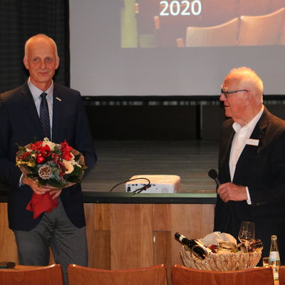 Bild vergr��ern: B�rgermeister Christoph Ewers �berreicht einen Blumenstrau� f�r die Frau von Theo Petera, die leider aus gesundheitlichen Gr�nden nicht an der Versammlung teilnehmen konnte