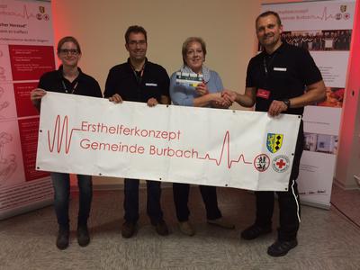 Bild vergr��ern: Ellen Fischer (2 v. r.) aus L�tzeln war die 1.000 Teilnehmerin an den Schulungen der Arbeitsgruppe �Ersthelferkonzept Gemeinde Burbach� und konnte sich �ber einen Gutschein f�r eine Erlebnis-F�hrung �ber den Siegerland-Flughafen im kommenden Jahr freuen.