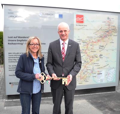 Bild vergr��ern: Offizielle Schl�ssel�bergabe: Die neue WC-Anlage in Burbachs Ortsmitte wurde jetzt von Annette Hering, Gesch�ftsf�hrerin des gleichnamigen Unternehmens, und von B�rgermeister Christoph Ewers ihrer Bestimmung �bergeben.