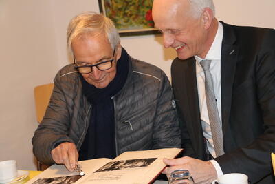 Bild vergr��ern: Wie vor 30 Jahren trug sich der ehemalige Bundesumweltminister Klaus T�pfer (l.) ins Goldene Buch der Gemeinde ein. Gemeinsam mit B�rgermeister Christoph Ewers bl�tterte er zun�chst zu seinem letzten Eintrag am 11. September 1992 zur�ck.