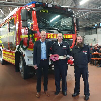 Bild vergr��ern: B�rgermeister Christoph Ewers �bergab den symbolischen Fahrzeugschl�ssel an den Leiter der Burbacher Feuerwehr, Gemeindebrandinspektor Markus Schwarze, und Einheitsf�hrer Tim Weber (v.l.).