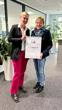Bild vergr��ern: Jana Dimter-Hammerstein (l.) der Firma connecT SYSTEMHAUS AG Siegen nimmt die wiederholte Auszeichnung zum Familienfreundlichen Unternehmen von Sabine Bartmann, Leiterin des Kompetenzzentrums Frau und Beruf, entgegen.