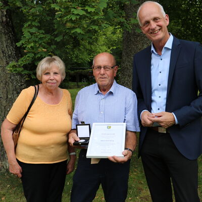 Bild vergr��ern: B�rgermeister Christoph Ewers (r.) gratuliert Karl Jung und dessen Frau Giesela zur Verleihung der Ehrenmedaille der Gemeinde in Silber.