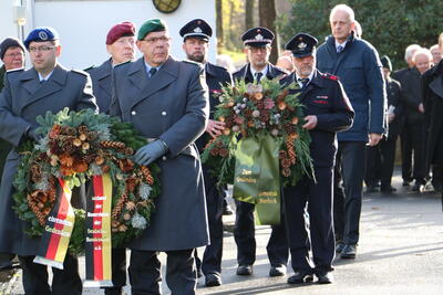 Bild vergr��ern: Vertreter der Reservistenkameradschaft Burbach (vorn) und der Freiwilligen Feuerwehr Burbach (hinten) legten die Kr�nze an das Ehrenmal.