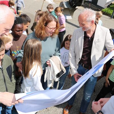 Bild vergr��ern: Gemeinsam mit den Sch�lerinnen und Sch�lern warfen B�rgermeister Christoph Ewers (l.), kommissarische Schulleiterin Katja Schmidt, Ortsvorsteher Dietmar Simmert und Planer Max Laufenberg (v.l.n.r.) einen Blick auf den Plan.
