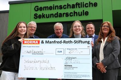 Bild vergr��ern: Schulsprecherin Emily Hufnagel, Schulleiter J�rgen Weber und sein Vertreter Andreas Stelzig sowie, NORMA-Bereichsleiterin Alexandra Staub, Verkaufsleiter Martin Wirtz und Anja Hunhold (v.l.n.r.), Bereichsleiterin f�r Aus- und Fortbildung, bei der �bergabe des symbolischen Spenden-Checks.