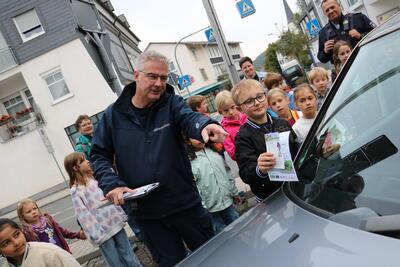 Bild vergr��ern: Ordnungsamtsmitarbeiter Stephan Hoffmann erhielt nun bei seinem Kontrollgang im Burbacher Ortskern tatkr�ftige Unterst�tzung von Sch�lerinnen und Sch�lern der Grundschule Burbach. Sie verpassten Parks�ndern im Rahmen der Europ�ischen Mobilit�tswoche einen �Denkzettel�.