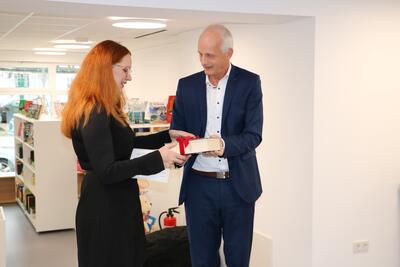 Bild vergr��ern: Versteckt in einer �dicken Schwarte� erhielt Magdalena Heide von B�rgermeister Christoph Ewers den symbolischen Schl�ssel zur B�cherei.