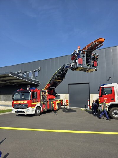 Bild vergr��ern: Ein Mitarbeiter war auf das Vordach der Halle gefl�chtet und wurde mit der Drehleiter von dort aus gerettet.