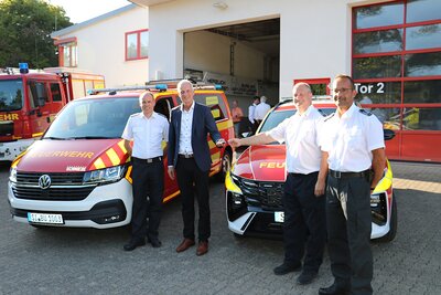 Bild vergr��ern: B�rgermeister Christoph Ewers (2.v.l.) �bergab dem Leiter der Burbacher Feuerwehr, Thorsten Schneider (3.v.l.), die Schl�ssel zum neuen Kommandowagen. Auch der neue Ger�tewagen f�r W�rgendorf wurde offiziell in den Dienst gestellt. Benjamin Scholl (l.) und Tobias Schmidt (r.) von der Wehrf�hrung freuten sich ebenfalls �ber die �Neuzug�nge�.