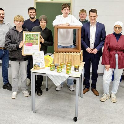 Bild vergr��ern: Lehrer Matthias Sauer, Tim Jonas Schmidt, Jonas Leyener (Westenergie), Emil Schoeppner, Andreas Bauer, Ben Petri, B�rgermeister Jonas Becker und Esraa Al Refai (v.l.n.r.) freuen sich �ber den 1. Platz der Gemeinschaftlichen Sekundarschule beim Burbacher Westenergie Klimaschutzpreis 2025.
