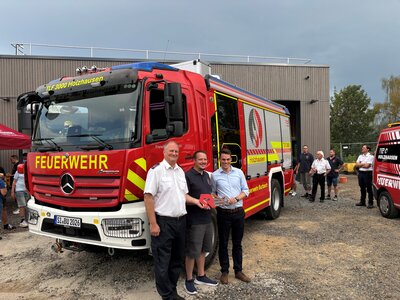 Bild vergr��ern: Thorsten Schneider (Leiter der Freiwilligen Feuerwehr Burbach), Thomas Waldrich (Einheitsf�hrer der Einheit Holzhausen) sowie Jonas Becker (B�rgermeister der Gemeinde Burbach) vor dem neuen TLF 3000.
