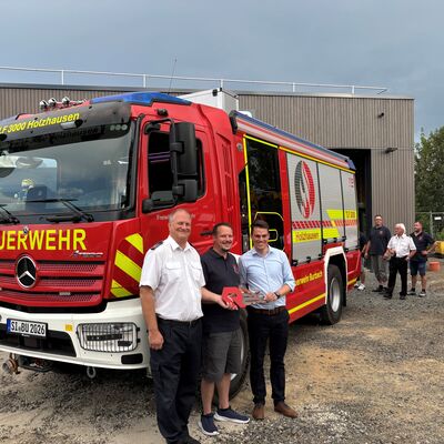 Bild vergr��ern: Thorsten Schneider (Leiter der Freiwilligen Feuerwehr Burbach), Thomas Waldrich (Einheitsf�hrer der Einheit Holzhausen) sowie Jonas Becker (B�rgermeister der Gemeinde Burbach) vor dem neuen TLF 3000.