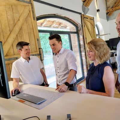 Bild vergr��ern: B�rgermeister Jonas Becker (2.v.l.) und Wirtschaftsf�rderer Christian Feigs (r.) lie�en sich von Dietrich und Tina Seibel in das T�tigkeitsfeld von fescon einf�hren.