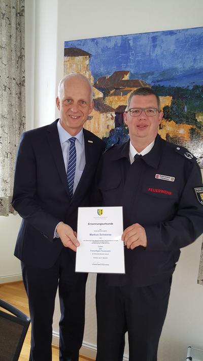 Bild vergr��ern: Neuer Leiter der Burbacher Feuerwehr ist der W�rgendorfer Markus Schwarze. B�rgermeister Christoph Ewers �berreichte ihm jetzt nach positivem Votum der Wehrleute wie auch des Rates die Ernennungsurkunde.