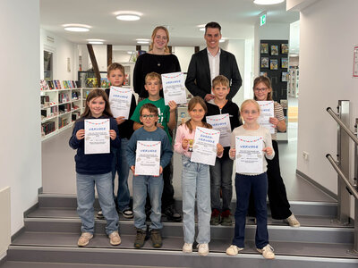 Bild vergr��ern: Die erfolgreichen Teilnehmerinnen und Teilnehmer des Sommerferien-Lesespa�es der Gemeindeb�cherei Burbach mit ihren Urkunden. B�rgermeister Jonas Becker und Magdalena Heide von der Gemeindeb�cherei gratulierten den Kindern zu ihrer Leseleistung.