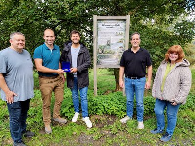 Bild vergr��ern: Westenergie-Kommunalmanager Jonas Leyener (3.v.l.) �bergibt Christopher F�rster (2.v.l.) den Lokalstar. Mit dabei sind die Waldgenossen Tobias Klein (l.) und Ralf Herr (2.v.r.) sowie Burbachs Umweltberaterin Elisabeth Fley (r.). 