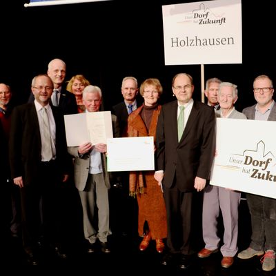 Bild vergr��ern: Bundeslandwirtschaftsminister Christian Schmidt �berreicht die Auszeichnungsurkunde an die Vertreter der Dorfgemeinschaft Holzhausen.